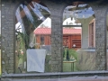 Custom-made transparent terrace tarp with a stone wall print and arched window cutouts for an outdoor patio enclosure.
