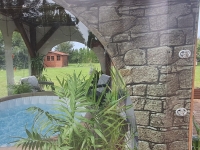 Durchsichtige Terrassenplane mit Maueraufdruck als Sichtschutz für Whirlpool im Garten mit Blick auf Pavillon und Pflanzen