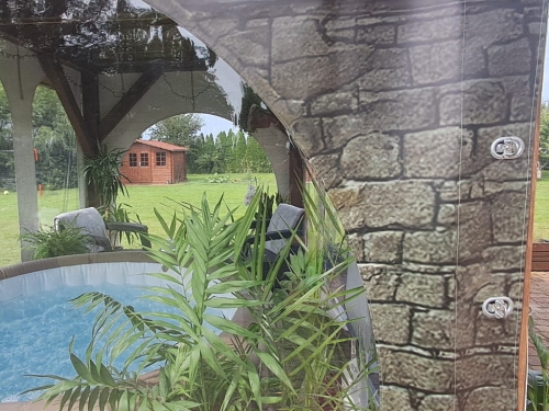 Transparent terrace tarpaulin with stone pattern print and clear window panels around a hot tub area