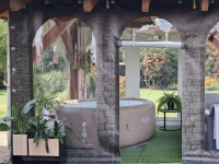 Transparente Terrassenplane mit Maueraufdruck zum Schutz eines runden aufblasbaren Whirlpools unter einer Überdachung