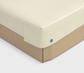 Coin d'une bâche de protection crème sur mesure avec œillet métallique, installée sur le rebord marron d'une remorque, ajustée aux dimensions