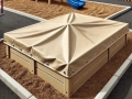Maßgeschneiderte beige Sandkastenabdeckung mit Metallbeschlägen, schützt Sand vor Verunreinigungen