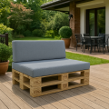 Comodo divano da giardino in pallet con cuscini grigi su una terrazza in legno davanti alla casa