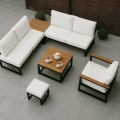Set di mobili da giardino moderni con cuscini bianchi, tavolo in legno e poltrona su una terrazza grigia