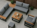 Moderne poltrone e divano da giardino grigi con finiture in legno su una terrazza accanto a un tavolino da caffè quadrato