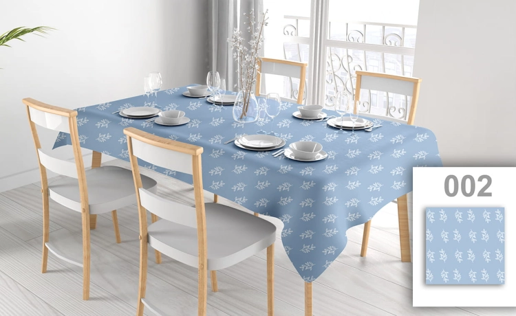 Custom blue tablecloth with white leaf pattern on a set dining table with chairs in a bright room