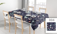 Custom printed floral tablecloth on a dining table set for four with white chairs and place settings.