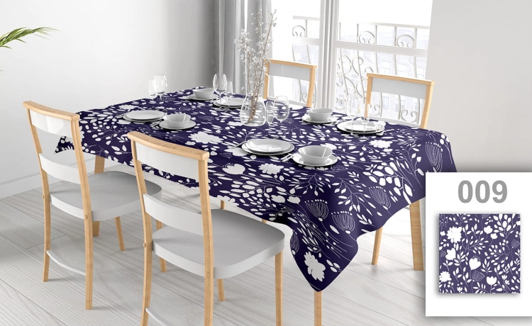 Vlekafstotend reclame-tafelkleed met wit bloemmotief op donkerblauwe achtergrond, uitgespreid op een eettafel