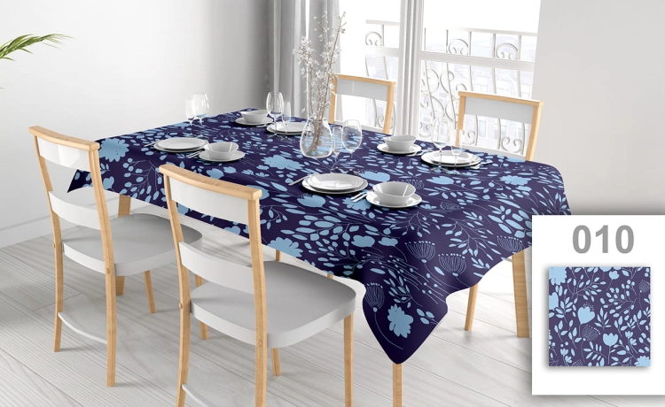 Custom floral tablecloth in navy blue and light blue with a modern nature pattern on a set dining table.