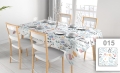 Custom floral tablecloth on a dining table set with dishes in a bright room with modern chairs