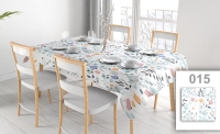 Custom floral tablecloth on a dining table set with dishes in a bright room with modern chairs