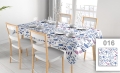 Custom spill-proof tablecloth with blue and pink floral pattern on a dining table with chairs and place settings