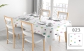 Custom stain-resistant tablecloth with colorful polka dot print on a dining table with chairs and place settings