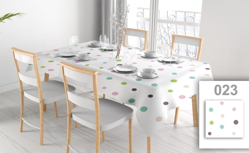 Wit vlekbestendig tafelkleed met gekleurde stippen op een eettafel met vier stoelen en elegant servies