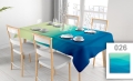 Stain-resistant rectangular tablecloth with a blue and green wave gradient print on a dining table with chairs