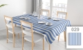 Custom blue and cream striped tablecloth on a dining table with chairs and place settings in a modern dining room