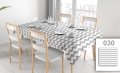 Custom stain-resistant tablecloth with grey and white chevron pattern on a dining table with chairs and place settings