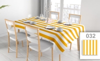 Custom striped tablecloth on a set dining table with white chairs in a bright room