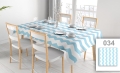 Blue and white chevron patterned tablecloth on a set dining table with chairs and place settings.