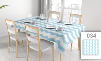 Blue and white chevron patterned tablecloth on a set dining table with chairs and place settings.