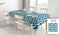 Custom stain-resistant tablecloth with a blue and white wavy pattern on a dining table with chairs and place settings