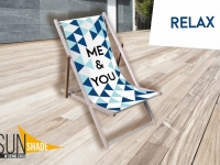 Werbe-Liegestuhl aus Holz mit geometrischem Muster und Aufschrift ME & YOU auf einer Terrasse neben dem Schriftzug RELAX