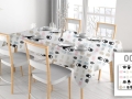 Custom spill-resistant tablecloth with a colorful pattern of teapots and cups on a dining table with chairs