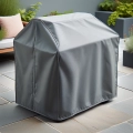 Cushioned grey waterproof custom cover protecting garden furniture on a stone patio terrace