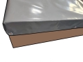Custom-sized gray PVC tarpaulin cover for a trailer with metal grommets for secure fastening