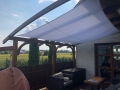 Weißes wasserdichtes Premium-Sonnensegel montiert über einer Terrasse mit Gartenmöbeln