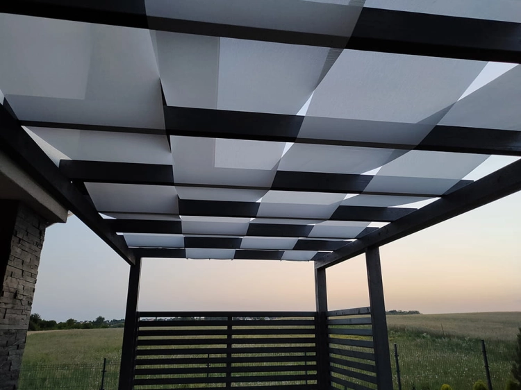 Economic white pergola sunshade sail woven between dark wooden beams in a modern terrace gazebo.