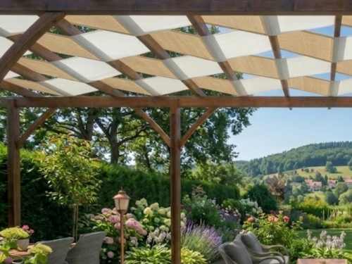 Two-tone waterproof shade sails woven through a wooden pergola overlooking a lush garden and rolling hills.