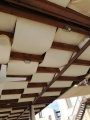Toldo de pérgola premium blanco impermeable montado bajo vigas de madera de terraza como protección solar