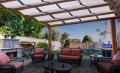 Toldo protector Premium blanco impermeable de 0,7x5 m montado en una pérgola de madera para terraza