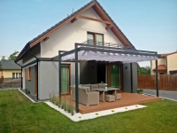 White retractable roman patio awning over a modern terrace with grey garden furniture and a wooden deck