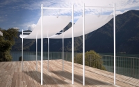 White waterproof roman wave shade sail for outdoor patio with mountain lake view in the background