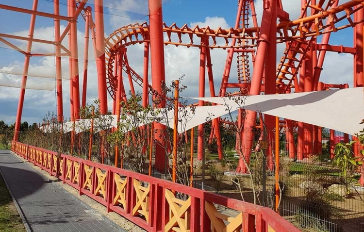 Waterdicht driehoekig Premium schaduwdoek beschermt een pad in een pretpark tegen de zon