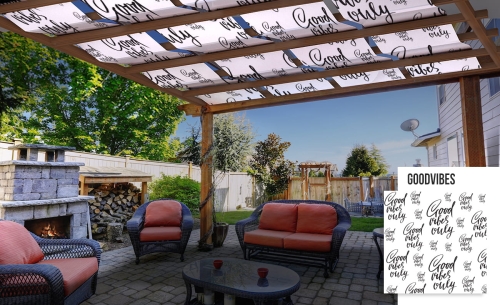 Wasserstreifen-Sonnensegel für Pergola mit schwarzem Schriftzug Good Vibes Only über einer Feuerstelle im Garten