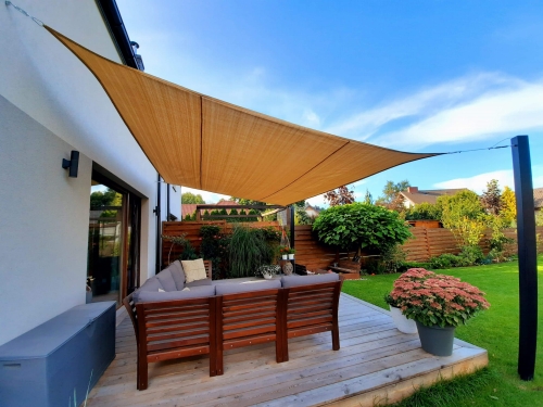 Sandfarbenes HDPE Sonnensegel nach Maß über einer Terrasse mit Gartenmöbeln und Holzdeck montiert