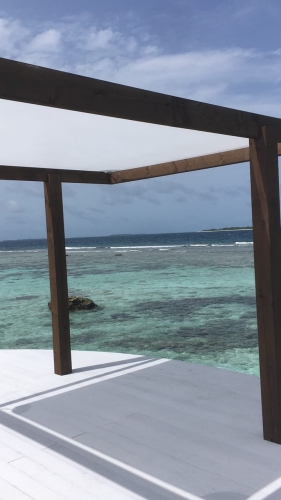 Quadratisches Sonnensegel 4,2x4,2 m montiert auf einer Holzpergola über der Terrasse am Meer