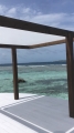 Toldo vela rectangular blanco 3,2x5 m instalado en una pérgola de madera sobre el agua
