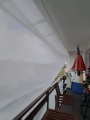 Wit rechthoekig schaduwdoek 3,2x5 m gemonteerd boven balkon blokkeert de zon en biedt schaduw