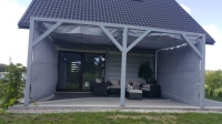 Custom-made waterproof gray roman blinds for a modern patio pergola with outdoor lounge furniture